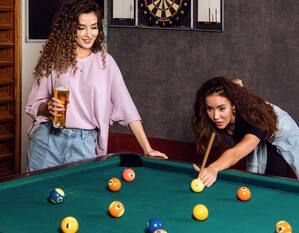 Two women playing pool