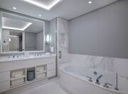 Bathroom with tub, vanity and two sinks