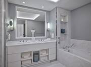 Bathroom with two sinks, vanity and tub