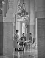 Man and woman at table, with staff member serving