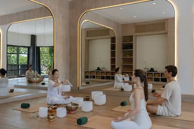 Mann und Frau werden von einem Kursleiter bei einer Audioheilung geführt