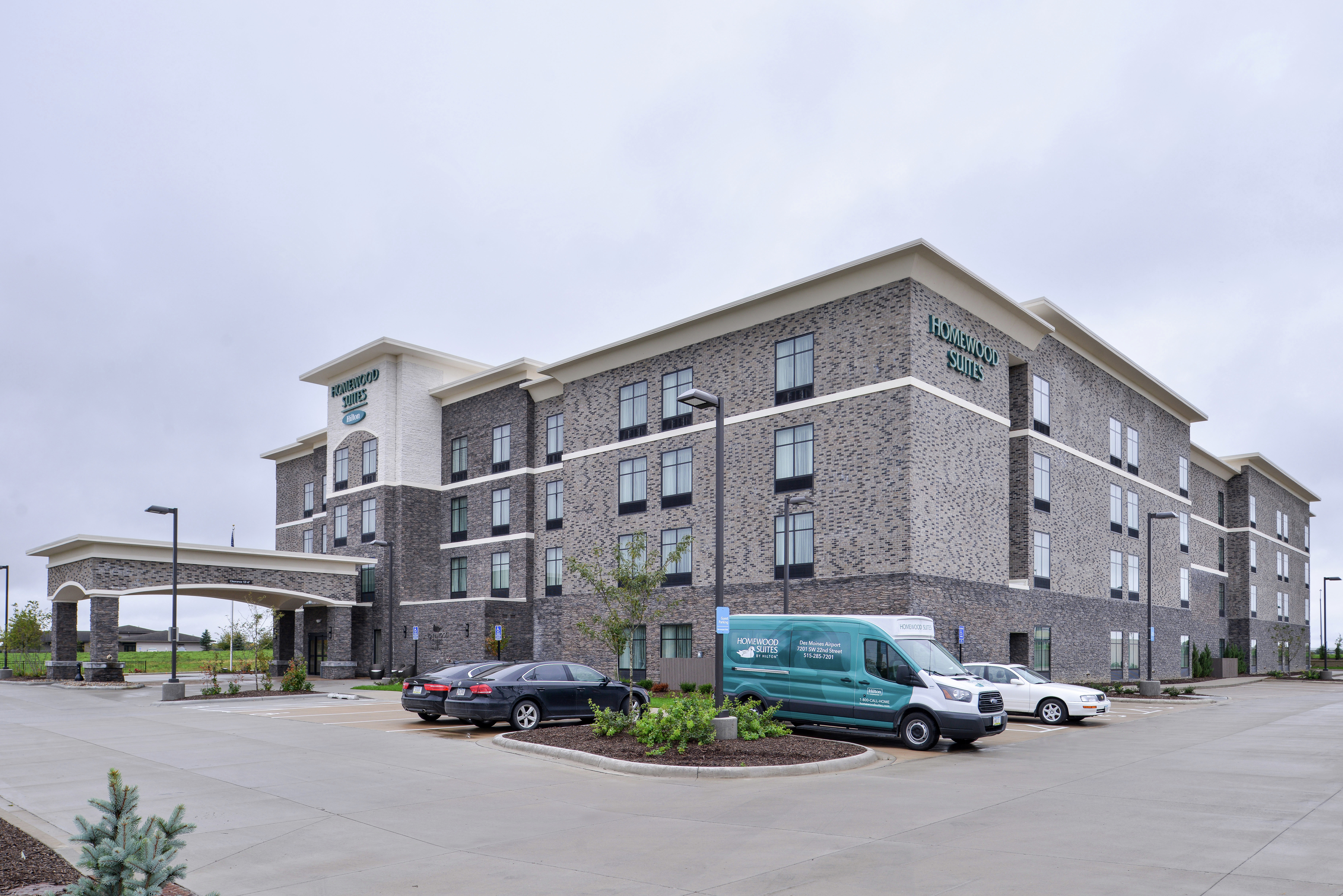 Daytime View of Hotel Exterior with Cars in Parking Lot