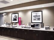 Breakfast serving area with buffet tray, oatmeal, microwave, toaster, and dining amenities