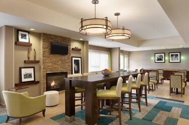 Lobby Seating Area with Chairs, Tables, Wall Mounted HDTV and Fireplace