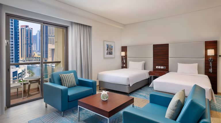 Two beds in room with chairs and table