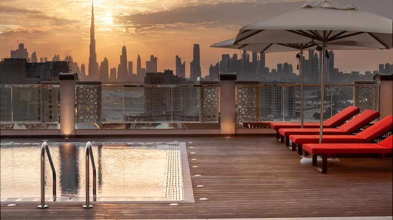 rooftop pool, lounge chairs, umbrellas, city view