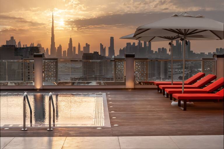 rooftop pool, lounge chairs, umbrellas, city view