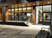 Iluminated Hotel Entrance, Exterior, Signage, Stairs and Bench Seating at Night