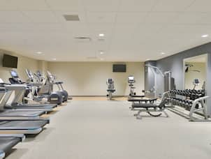 Fitness Center With Cardio Equipment, TVs, Weight Machine, Weight Benches, Free Weights, and Large Mirrors