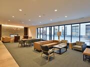 Soft Seating, Fireplace, Tables, and Lamp in Lobby Lounge Area With Large Windows