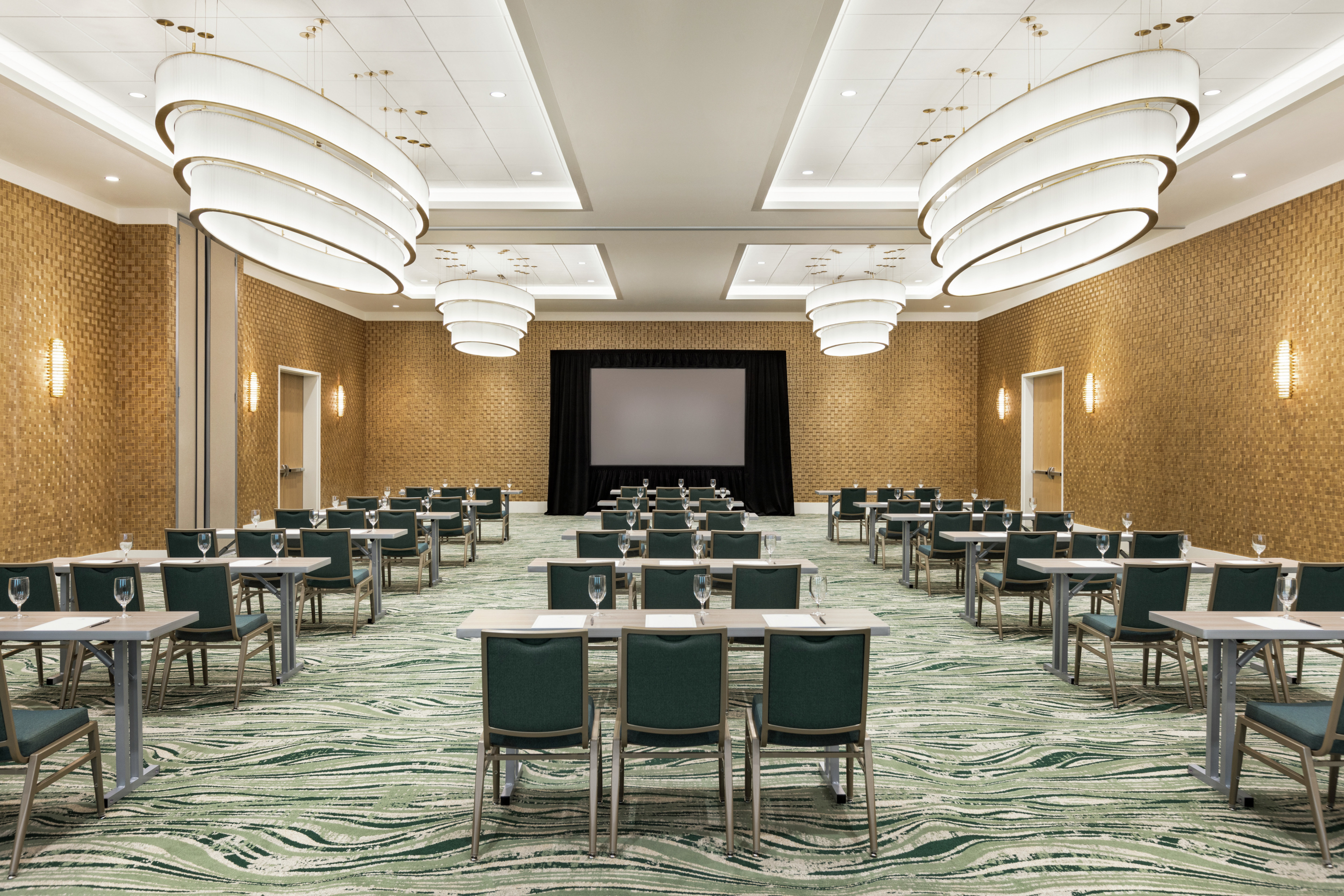Convenient, oversized, on-site meeting room with classroom table set up and large projector screen at front of room
