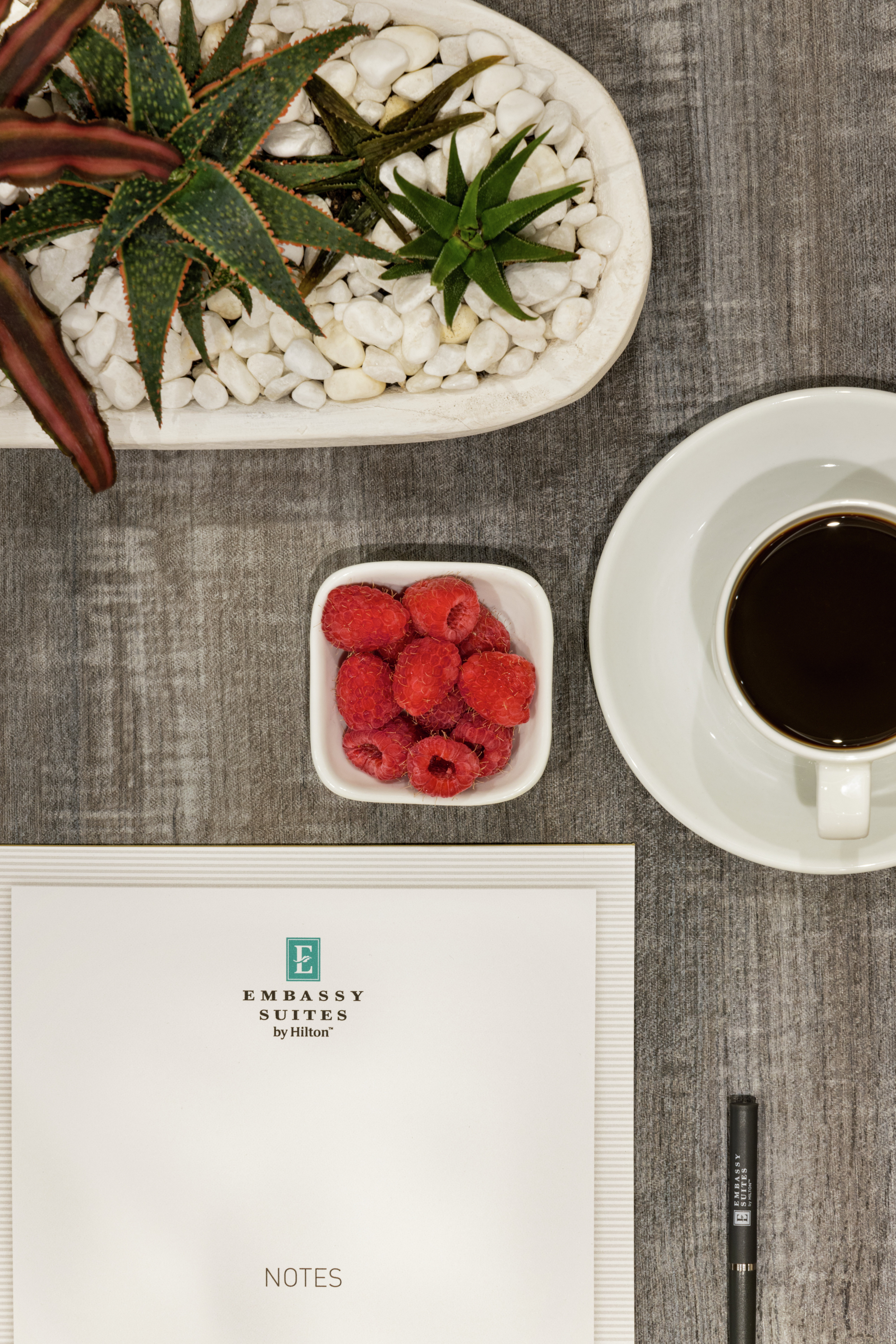 Detail of Embassy Suites meeting room place-setting with notepad, pen and coffee