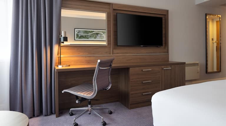 Bed in room with workdesk and TV