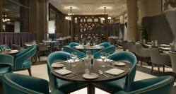 Booths, Green Chairs, Dining Tables With Place Settings and Glasses in Bread Street Brasserie Restaurant
