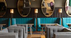 Decorative Lighting Above Mixed Seating Options, Illuminated Lamps, and Large Oval Mirrors in Lounge Area of Monboddo Bar
