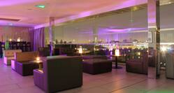 Lounge Seating, Large Window With View of Illuminated City at Night, and Purple Lighting in SKYBar