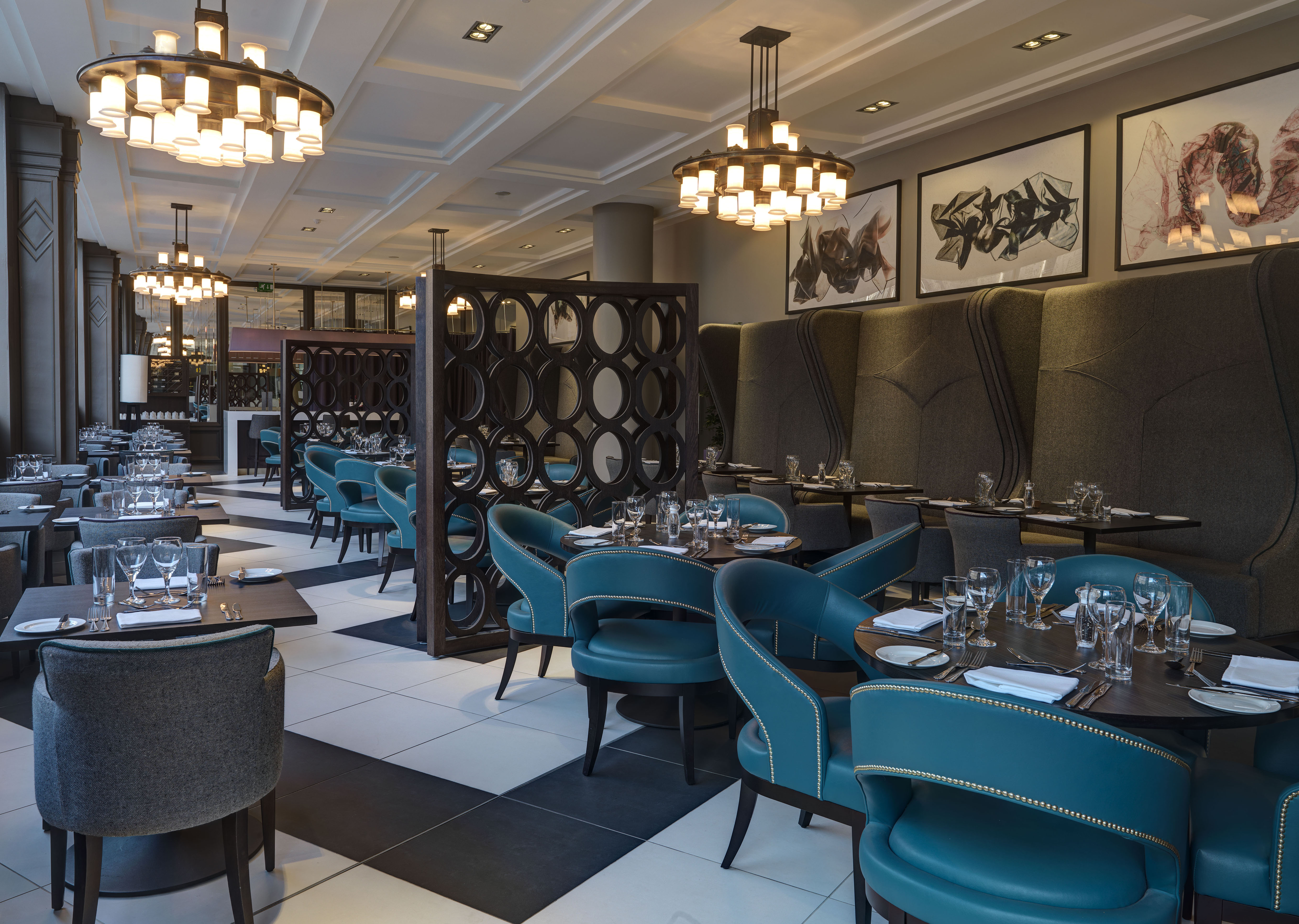 Wall Art, Booths, Chairs and Dining Tables With Place Settings and Glasses in Bread Street Brasserie Restaurant