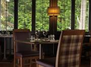 Restaurant Table Set for Two and Illuminated Floor Lamp By Large Window With Open Blinds