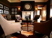 Wall Art, Table, Armchairs, Mirror Above Fireplace, and Window in Bar Lounge Area