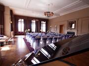 Open Grand Piano and White Chairs With Blue Bows Arranged Theater Style in Stuart Lounge Set Up for Wedding Ceremony