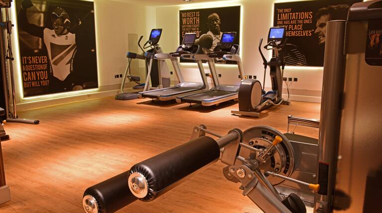 Fitness Center With Inspirational Wall Murals, Cardio Equipment, and Weight Machine