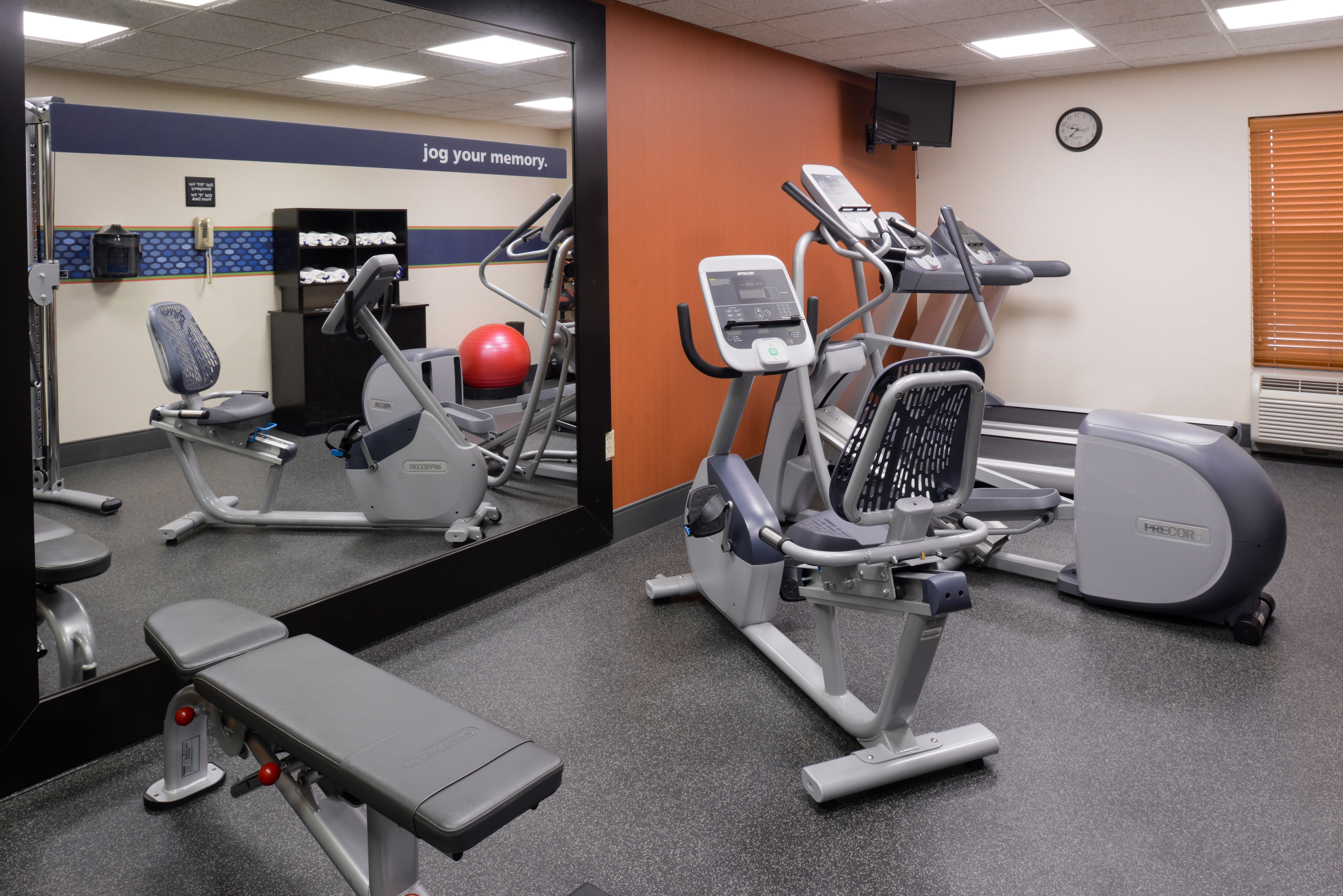 Cardio Equipment and Weight Bench in front of Mirror