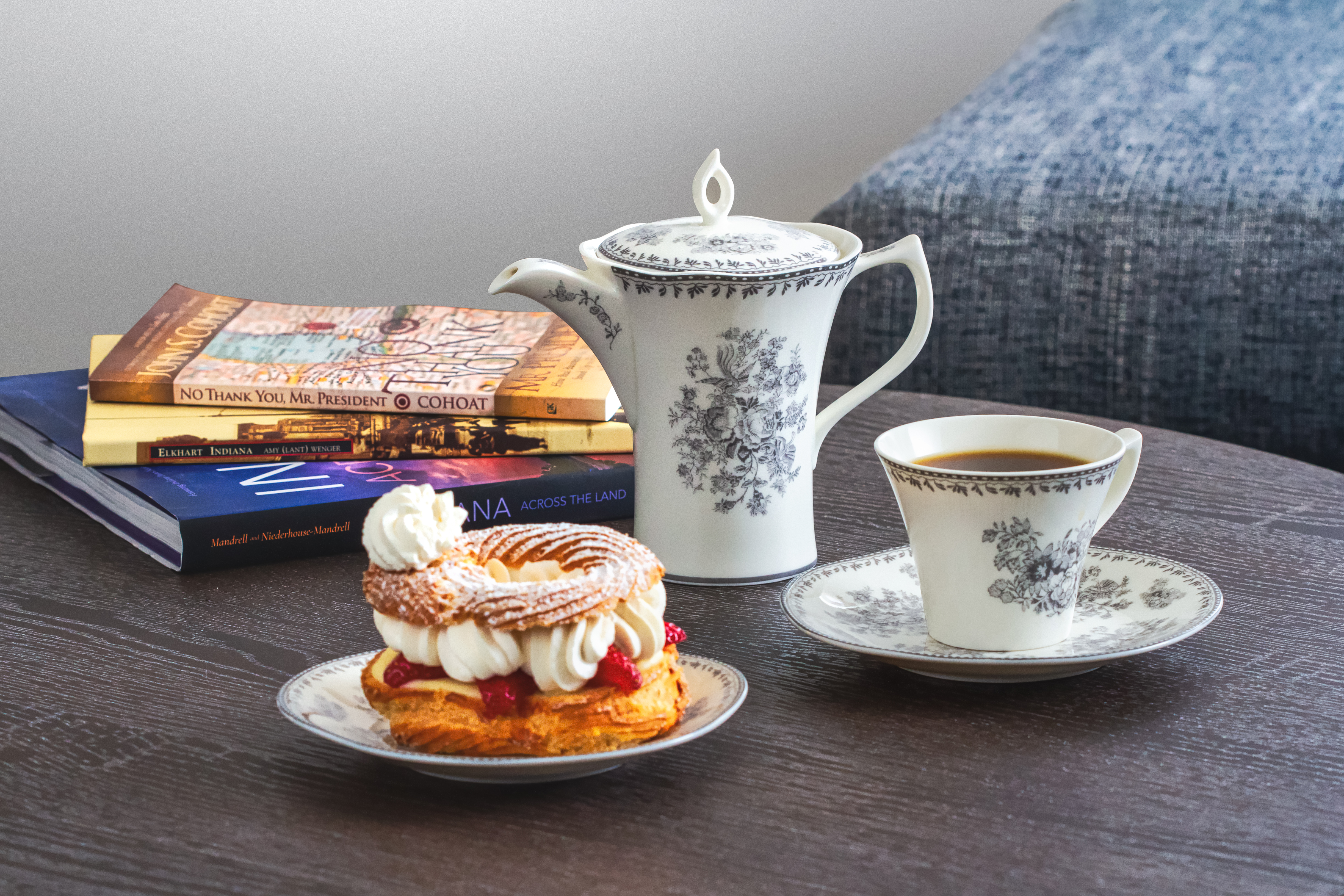 dessert display, strawberry shortcake, coffee cup, coffee pot, books