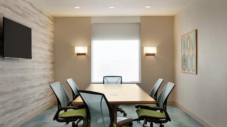 Bright On-Site Meeting Room Featuring Boardroom Table And TV