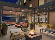 Beautiful Outdoor Lounge Area Featuring Comfortable Seating, Firepit, And Gazebo With String Lights