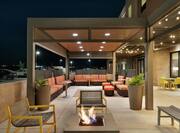 Beautiful Outdoor Lounge Area Featuring Comfortable Seating, Firepit, And Gazebo With String Lights