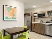 Spacious Kitchen Area In Suite Featuring Dining Table, Refrigerator, Dishwasher, And Microwave