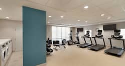 Bright Fitness Center With Ample Space, Exercise Equipment, And Convenient Guest Laundry