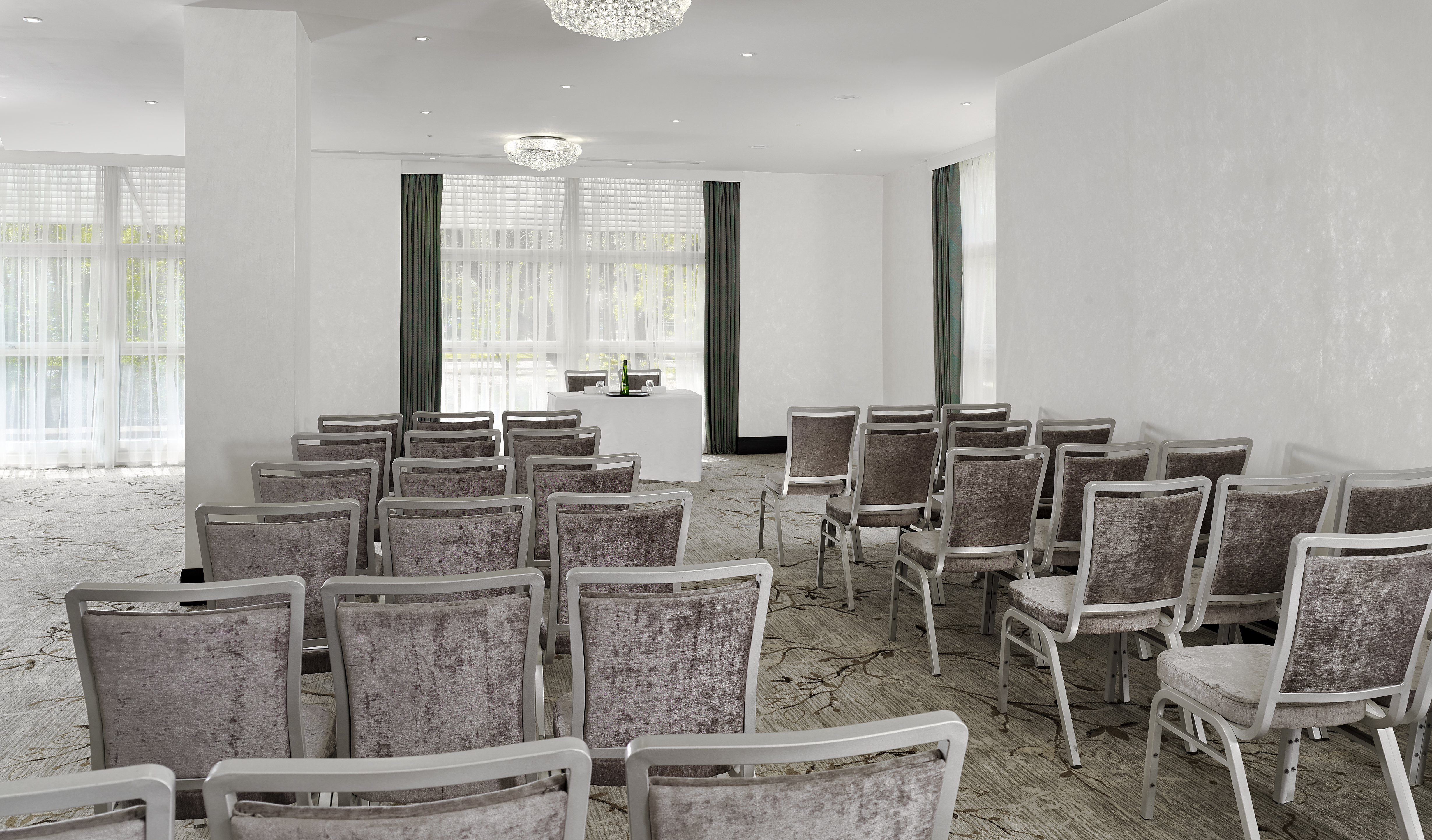 Garden Suite Arranged Theater Style With Rows of Chairs Facing a Table and Windows