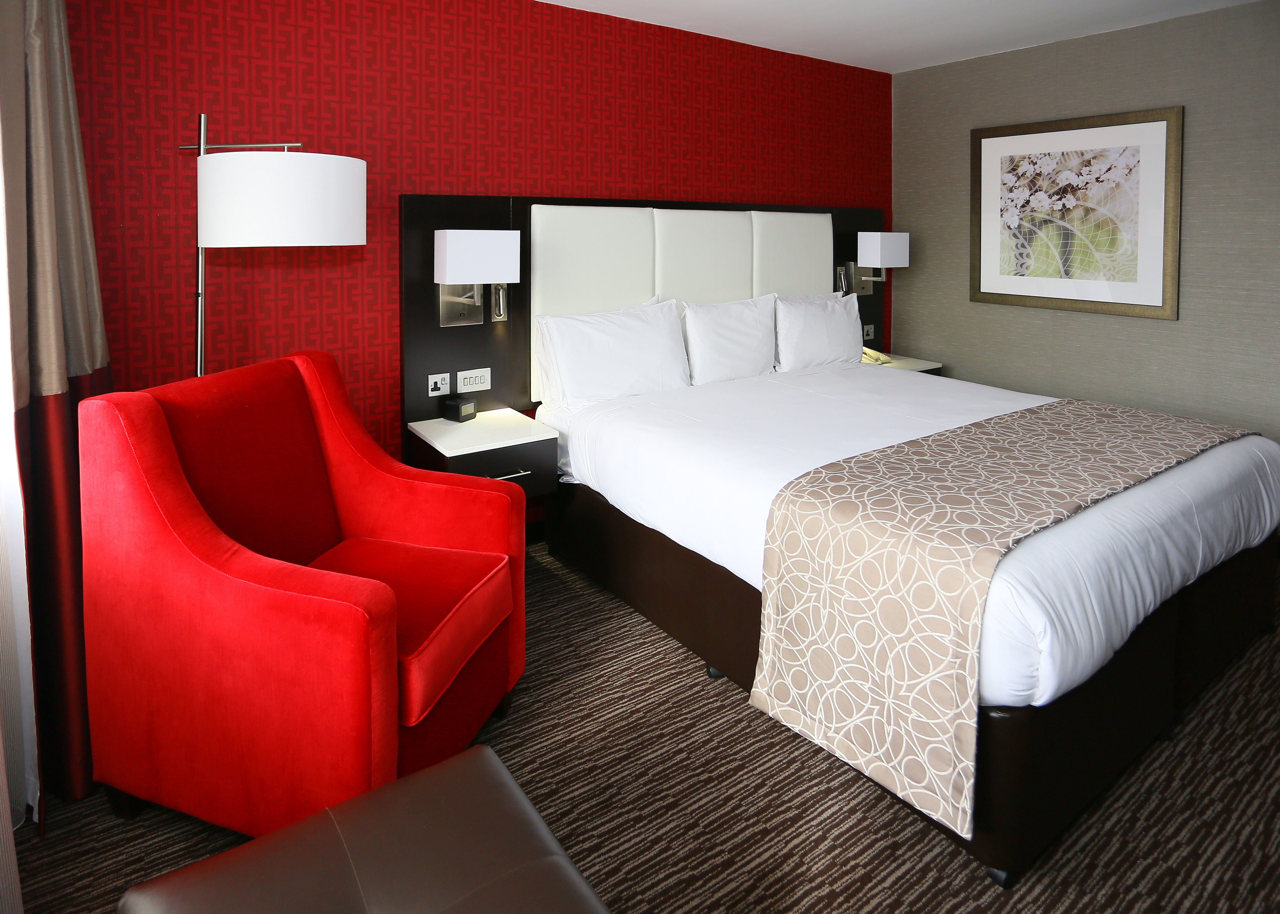 Red Srmchair, Floor Lamp, Lamps Above Bedside Tables, King Bed and Wall Art in Guest Room