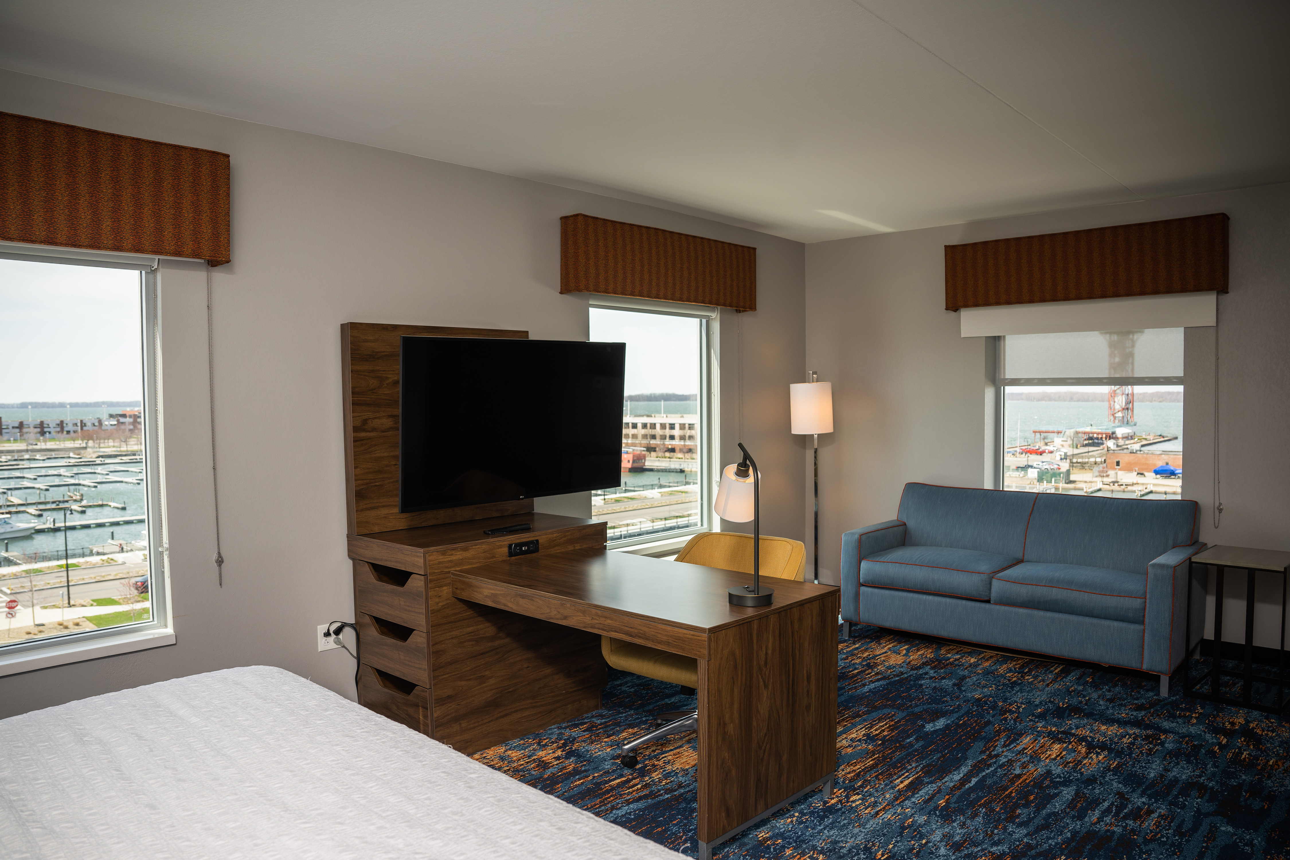 Desk, HDTV, Sofa and Large Bed in a Room with Marina View