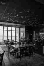 Tables and chairs near window view at Oliver's Rooftop Restaurant