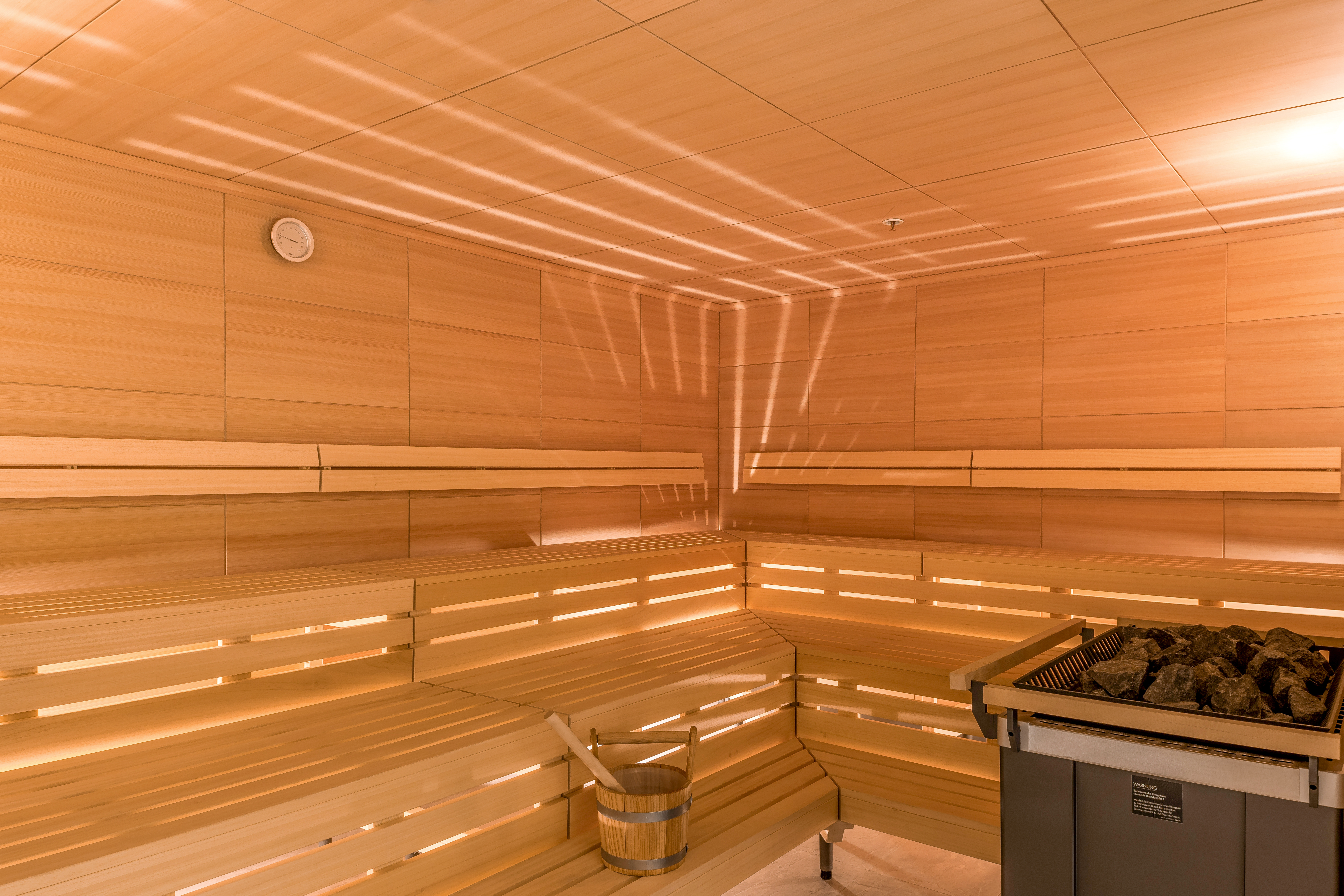 Wooden Sauna Interior With Ladle in a Bucket and Heater at Atmosphere SPA