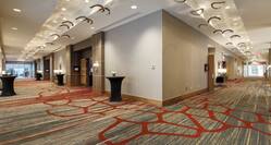 Prefunction Area Outside Ballroom With Cocktail Tables and Two Entry Doors at end of Each Corridor