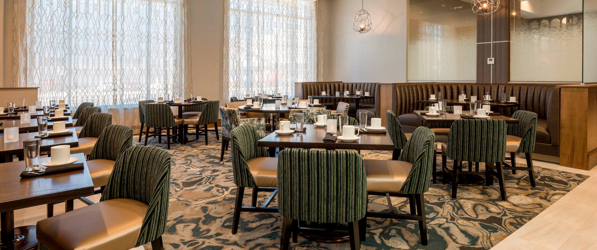 Place Settings on Tables, Chairs, Booth Seating, and Large Windows With Sheer Drapes in Stone City Grill Dining Area