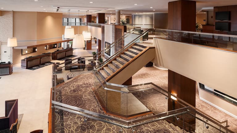 Overview of Check- in Desk, Tables, Lounge Seating, Lighting and Staircase in Lobby