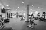 Bright fitness center fully equipped with new cardio machines weights and TV 