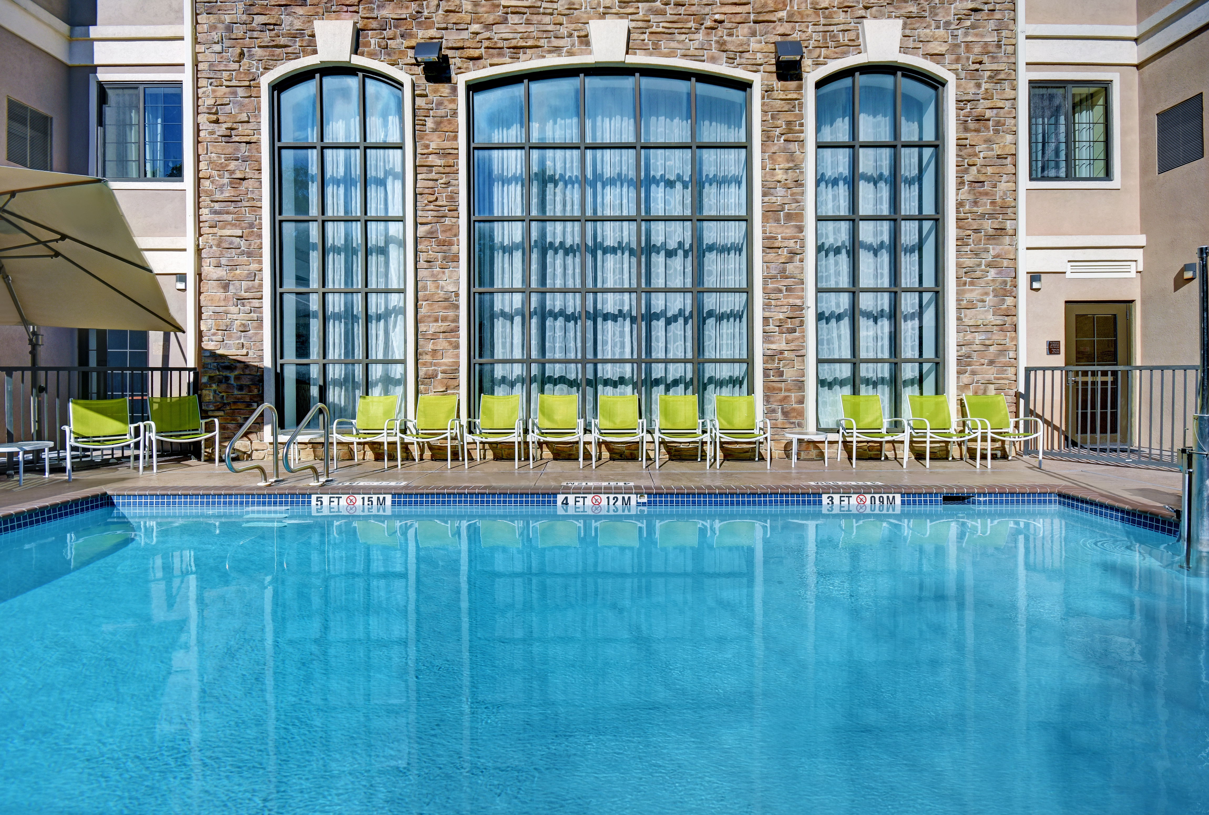 outdoor swimming pool with seating in the day