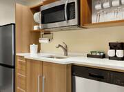 Full equipped kitchen in suite featuring dishwasher, coffee maker, microwave, and full size refridgerator..