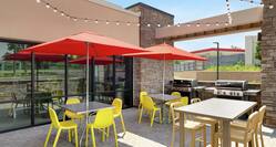 Beautiful outdoor patio featuring patio tables, string lights, and complimentary barbaque grills for guests to enjoy.