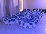 Overview of Banquet Hall Decorated for an Event with Round Tables and Colored Lights