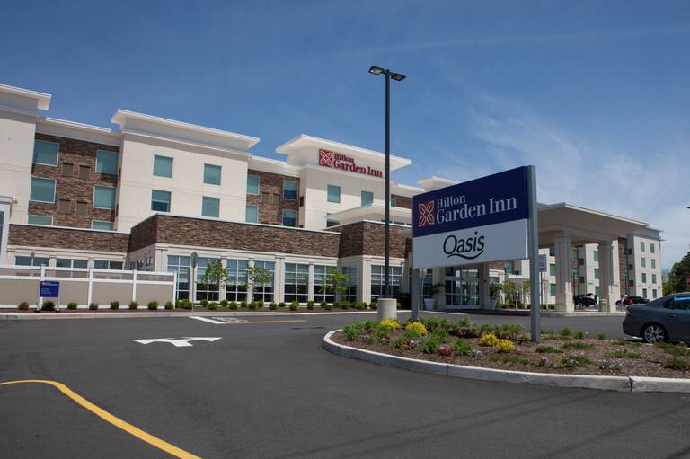 Hotel Exterior, Signage, Front Entrance, and Parking Lot on a Sunny Day