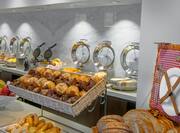 Breakfast Bar Area with Hot Foods Wafflemakers Breads Pastries and Fresh Fruits