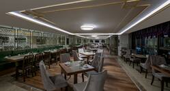 Tables, Chairs, Booths, and Windows With Night View in Restaurant Dining Room Area