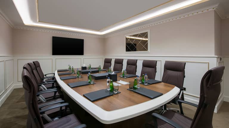 Seating for 11 at Boardroom Table With Bottled Water and Notepads, and TV Presentation Screen