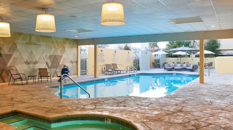Covered Pool and Whirlpool  With Tables, Chairs and Tables With Sun Umbrellas on Outdoor Patio